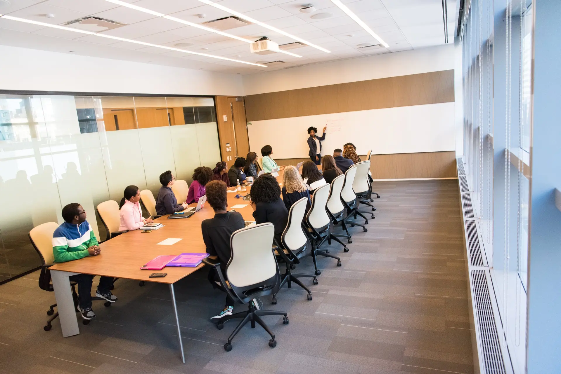 Young people seated around a corporate boardroom table during a workplace visit