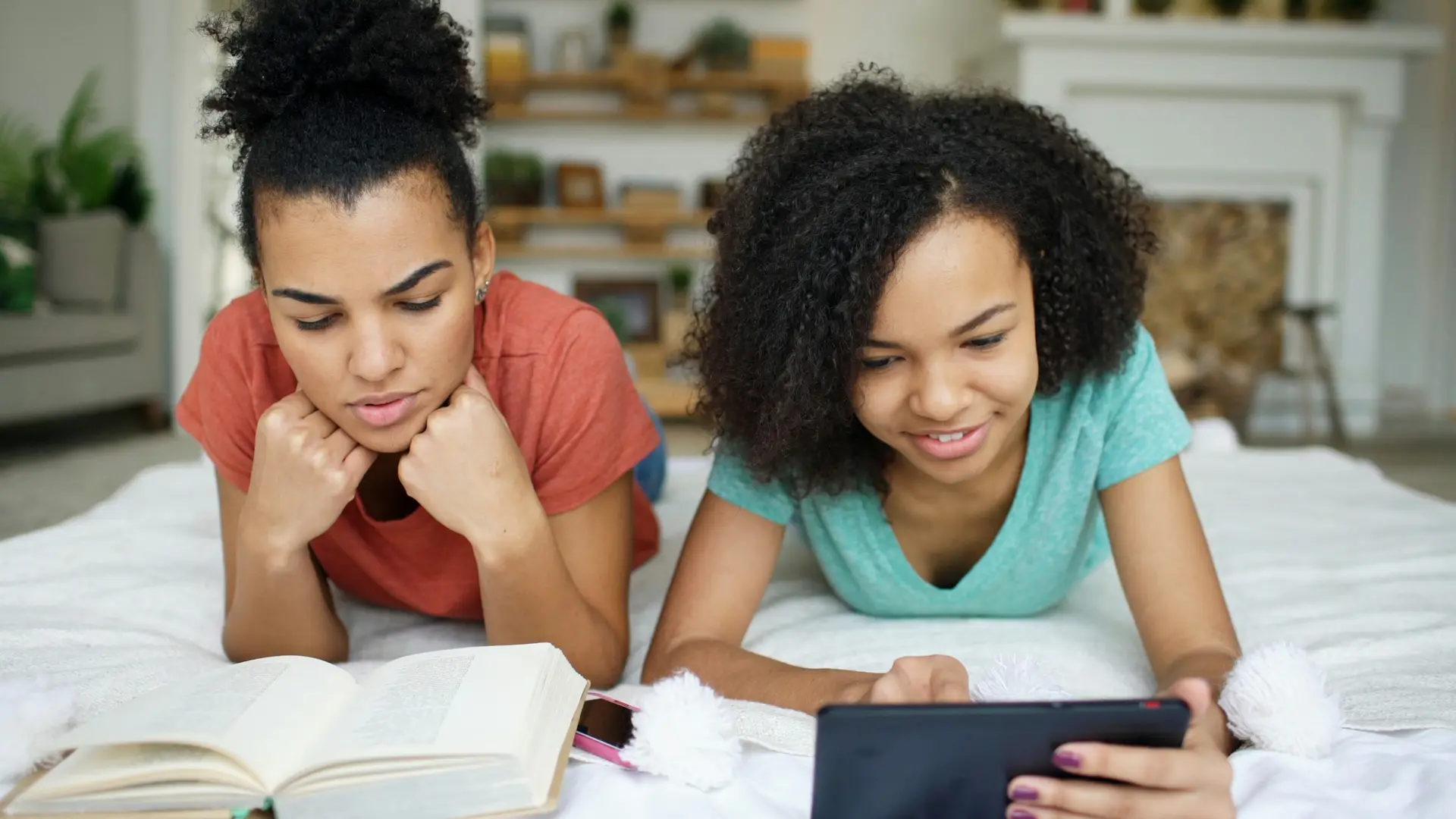 Two teenage girls reading and researching together
